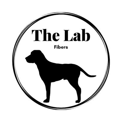 The Lab Fibers Logo - a silouhette of a Black lab with the text "The Lab Fibers" above it with an artistic circle around both. 