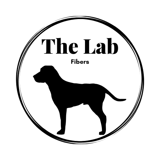 The Lab Fibers Logo - a silouhette of a Black lab with the text "The Lab Fibers" above it with an artistic circle around both. 