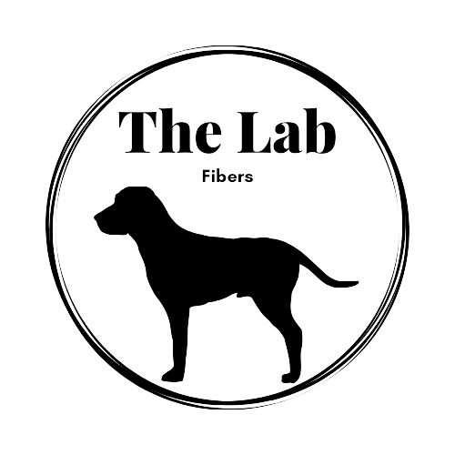 The Lab Fibers Logo - a silouhette of a Black lab with the text "The Lab Fibers" above it with an artistic circle around both. 